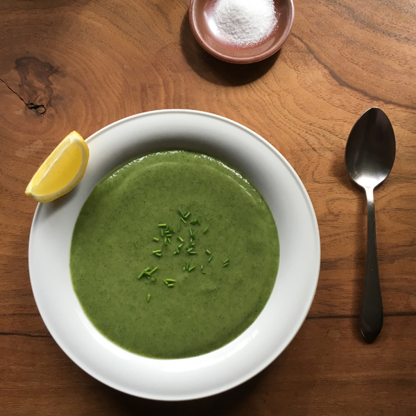 Creamy stinging nettle and potato soup served with fresh lemon